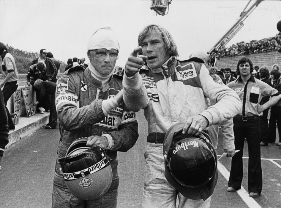 Racing drivers Niki Lauda (left) and James Hunt (1947 - 1993) after both were involved in a multiple collision and forced to retire at the start of the Belgian Grand Prix